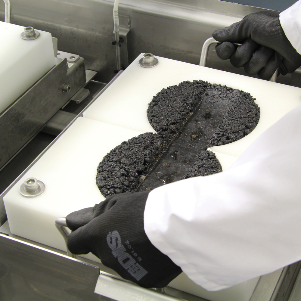 Colocación manual de probetas asfálticas en el equipo